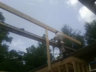 Carpenter setting a ridge beam over a new addition frame — Ice Dam Removal by Roofing Brothers in Roxboro