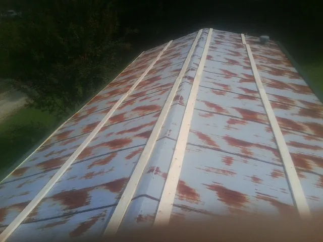 Rusted metal roof panels with new wood purlins before replacement — Storm Damage Roof Repair in Roxboro by Roofing Brothers