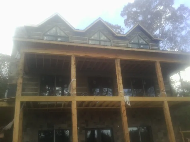 Dormers and porch framing on a large log home under construction — Roof Coating work by our crew in Roxboro