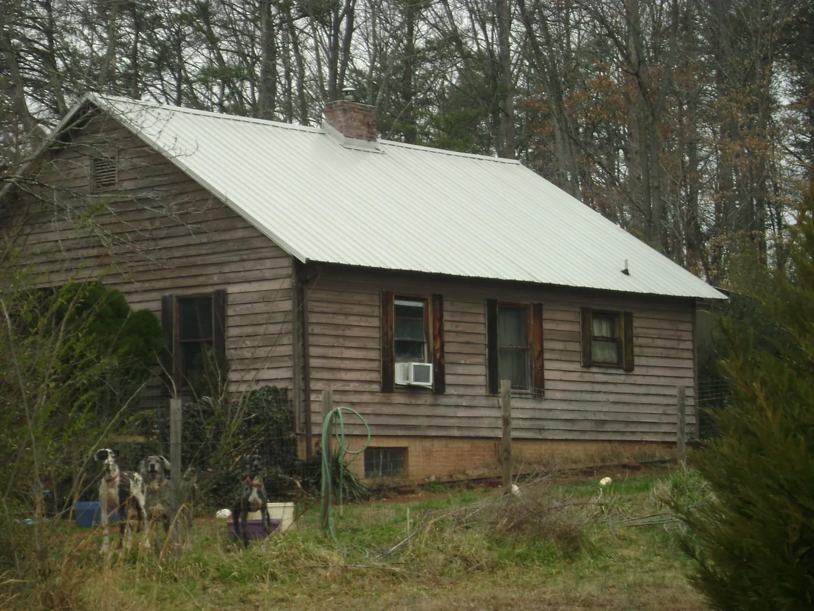 White metal roof on an old wood sided farmhouse, from a Metal Roof Installation job in Roxboro